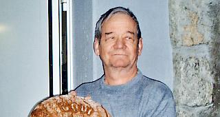 Der ehemalige Ausserberger B&auml;cker Gottlieb Schmid mit einem der bekannten Roggenbrote.