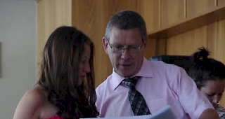 Schuldirektor Schwery &uuml;berreicht einer Sch&uuml;lerin ihr OS-Diplom.