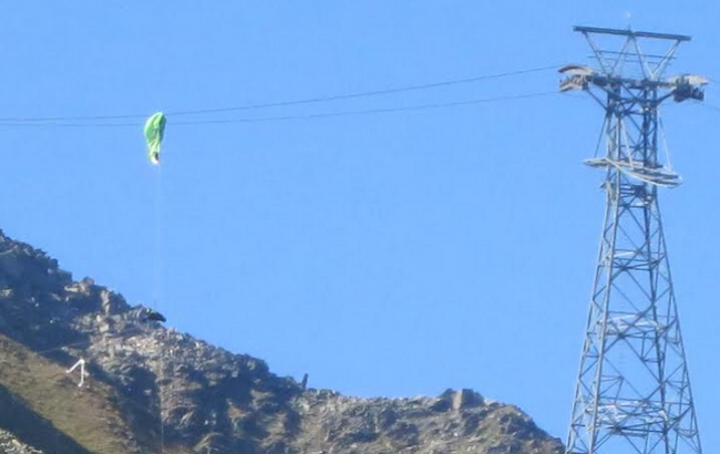 Gesichert an einem Seil wird der Pilot zum Boden abgeseilt.