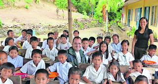 Mahlzeit. Auswanderer Vinzenz Pfammatter aus Eischoll inmitten zufriedener philippinischer Schulkinder. 