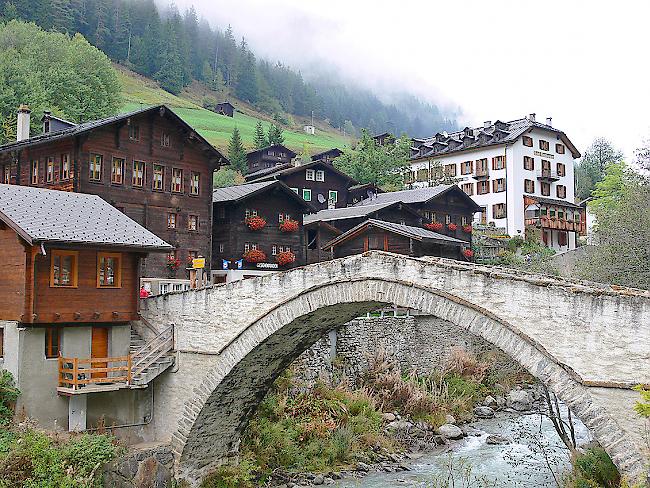 Das mehrstöckige Schulhaus in Binn (links neben der Brücke) muss saniert werden.