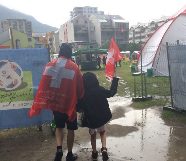 Lonza-Arena Visp: Auch wenn der Wind nachgelassen hat, das grösste Public Viewing im Oberwallis steht im Regen. Gleichwohl haben sich insgesamt mehr als 50 Leute in den «Seewjine» eingefunden. Sie sehen eine druckvolle Startphase der Polen.