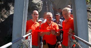 Reinhard Bittel, Pr&auml;sident des Vereins H&auml;ngebr&uuml;cke Aspi-Titter, schneidet an der Einweihung das Band durch. Dabei wird er vom Vize-Pr&auml;sidenten Patrick Bizeau (links) und Kassier Peter Dittus flankiert. 
