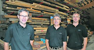 Wertvolle Lagerhalle. Die Holzbau Weger AG verf&uuml;gt &uuml;ber ein reich best&uuml;cktes Arsenal an uraltem Bauholz: Ulrich Weger mit zwei seiner 24 Mitarbeiter Hermann Weger und Helmut Werlen (v. links).  