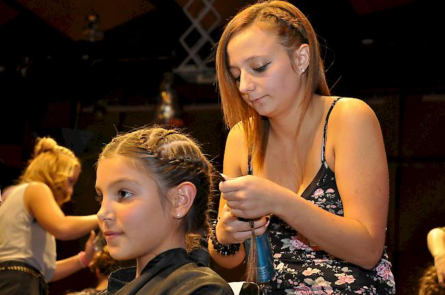 Lernende des 1. Lehrjahrs dreht Zöpfchen ins Haar.