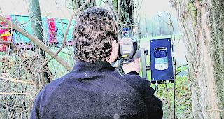 Ein Polizist f&uuml;hrt eine Geschwindigkeitskontrolle mit einem Lasermessger&auml;t durch.