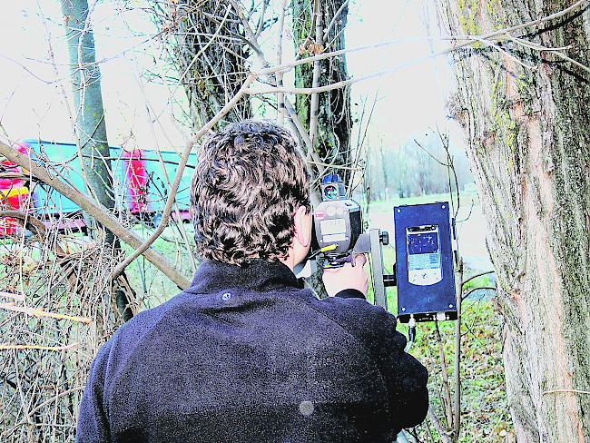 Ein Polizist führt eine Geschwindigkeitskontrolle mit einem Lasermessgerät durch.