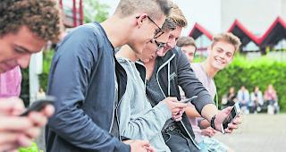 Sch&uuml;ler mit Smartphones. An vielen Oberwalliser Schulen ist die Nutzung der mobilen Ger&auml;te limitiert.  