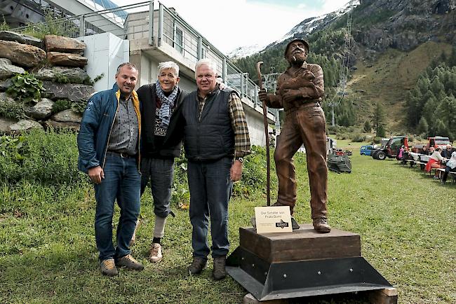 Daniel Luggen, Kurdirektor Zermatt Tourismus, übergibt die Holzskulptur «Der Schäfer von Prato Borni» an Urs Biner, Erfinder von Wolli, und Ruedi Julen, Präsident Zermatter Schwarznasen Schafzucht Genossenschaft.