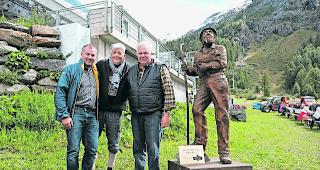&Uuml;bergabe. Daniel Luggen, Kurdirektor Zermatt Tourismus, &uuml;berreicht die Holzskulptur &laquo;Der Sch&auml;fer von Prato Borni&raquo; an Urs Biner, Erfinder von Wolli, und Ruedi Julen, Pr&auml;sident Zermatter Schwarznasen Schafzucht Genossenschaft. 