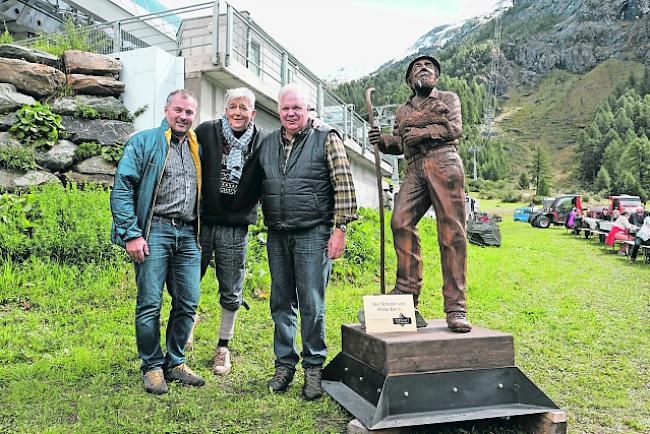 Übergabe. Daniel Luggen, Kurdirektor Zermatt Tourismus, überreicht die Holzskulptur «Der Schäfer von Prato Borni» an Urs Biner, Erfinder von Wolli, und Ruedi Julen, Präsident Zermatter Schwarznasen Schafzucht Genossenschaft. 