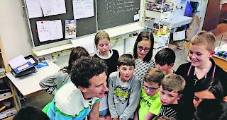 Anspruchsvolles Publikum. Zauberer Lionel mit einer f&uuml;nften Klasse aus Sissach.  