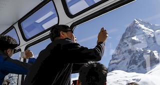 Am Fotografieren. Asiatische Touristen mit der Jungfrau-Bahn unterwegs zwischen Wengen und der Kleinen Scheidegg.