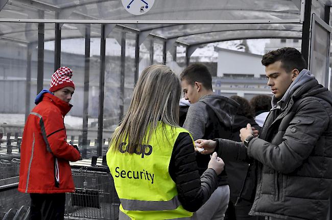 Coop-Mitarbeitende verteilt Jetons für den Gebrauch von Einkaufswagen.