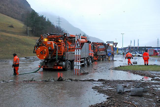 Einsatzkräfte pumpen auf der alten Kantonsstrasse beim Kreisel Abzweigung Lalden Wasser ab.