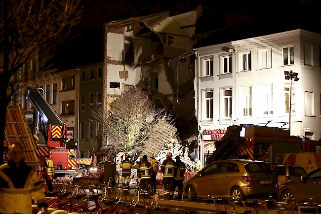 Feuerwehrleute inspizieren die Trümmer.