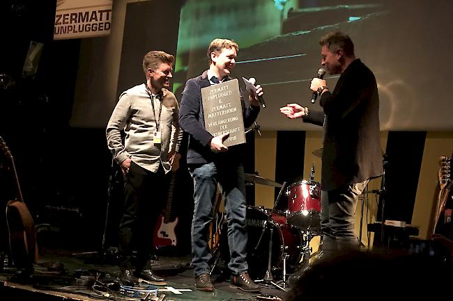 Paul-Marc Julen von Zermatt Tourismus (in der Mitte) überreicht Rolf Furrer (links) und Thomas Sterchi (rechts) von Zermatt Unplugged symbolisch eine Steinplatte.