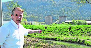 Problem. Gemeindepr&auml;sident Philipp Schnyder zeigt auf die L&ouml;cher, die der Biber in den Hochwasserschutzdamm gegraben hat. Im Hintergrund die Industriezone von Steg, die von diesem Damm gesch&uuml;tzt werden soll. 