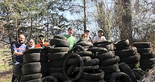 Eine Gruppe freiwilliger Helfer und eine Vielzahl von eingesammelten weggeworfenen Pneus.