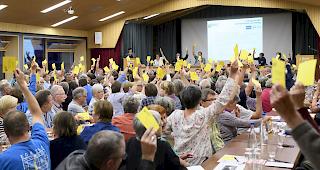 Teilnehmer der Gemeindeversammlung stimmen am Freitagabend betreffend der Olympiakandidatur f&uuml;r die Winterspiele Sion 2026 ab.