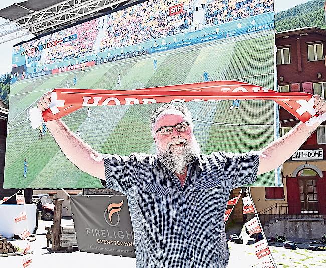 Pfarrer Christoph Gysel vor der Leinwand des Public Viewing in Saas-Grund.