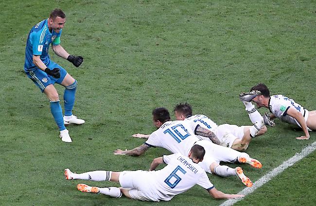 Die jubelnden Russen fallen ihrem Goalie und Penaltyheld Igor Akinfejew vor die Füsse.