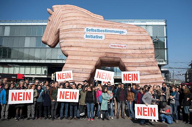 Personen demonstrieren mit Plakaten und einem Trojanischen Pferd gegen die Selbstbestimmungsinitiative der SVP.