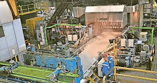 Walzanlage. Ein massiver Barren wird auf einen Millimeter ausgewalzt und dabei stets gek&uuml;hlt.