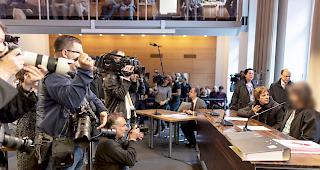 Maria sitzt am Mittwoch zum Prozessbeginn von Medien umgeben im Gerichtssaal des Amtsgerichts Freiburg.