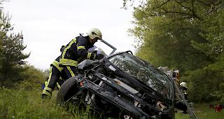 Die Feuerwehr versucht, die zwei Insassen aus dem Fahrzeug zu befreien.