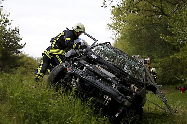 Die Feuerwehr versucht, die zwei Insassen aus dem Fahrzeug zu befreien.