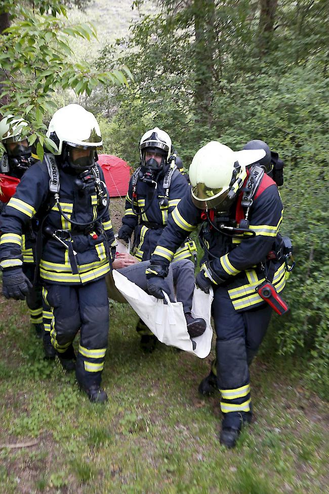 Eine Person wird von der Feuerwehr aus ihrem Zelt gerettet.