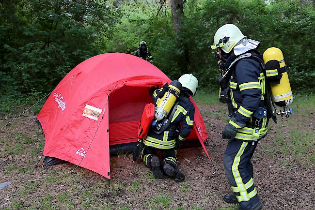 Rettung. Die Person im Zelt ist betrunken und kriegt vom Feuer nichts mit.