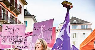 F&uuml;r Gleichberechtigung. Immer ernst, aber gerne mit einer Prise Humor. Streikende mit einem Scheuerbesen als Fahnenstange.