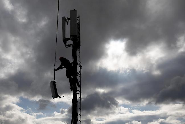 Ein Installationsfachmann montiert im Auftrag der Swisscom ein 5G Antennelement.