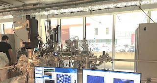 <b>Das NAP-XPS.</b> Im Hintergrund das R&ouml;ntgen-Photoelektronenspektrometer, auf den Bildschirmen die durch das Instrument erm&ouml;glichten Abbildungen der Atomstrukturen.