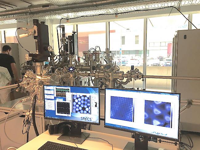 <b>Das NAP-XPS.</b> Im Hintergrund das Röntgen-Photoelektronenspektrometer, auf den Bildschirmen die durch das Instrument ermöglichten Abbildungen der Atomstrukturen.