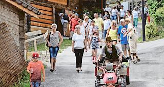 D&uuml;nit&uuml;. Stefan Werlen (auf dem Traktor) und Damian Gsponer (mit Strohhut) erz&auml;hlten die Geschichte Indens beim Dorfrundgang auf ihre Art.