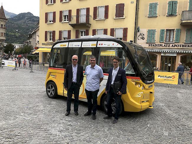 Willy Garbely (PostAuto), Patrick Hildbrand (Stadtrat) und Roland Imhof (Stadtarchitekt, von links) vor dem selbstfahrenden Postauto "SmartShuttle" in der Briger Innenstadt.