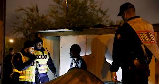 Franz&ouml;sische Polizeibeamte evakuieren am Donnerstag einen Migranten w&auml;hrend einer grossen Operation zur R&auml;umung provisorischer Migrantenlager.