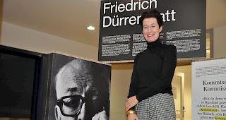 Madeleine Betschart neben einem Portr&auml;t Friedrich D&uuml;rrenmatts: die Ausstellung Helvetismen lockt noch bis am 1. Februar in die Mediathek Brig.
