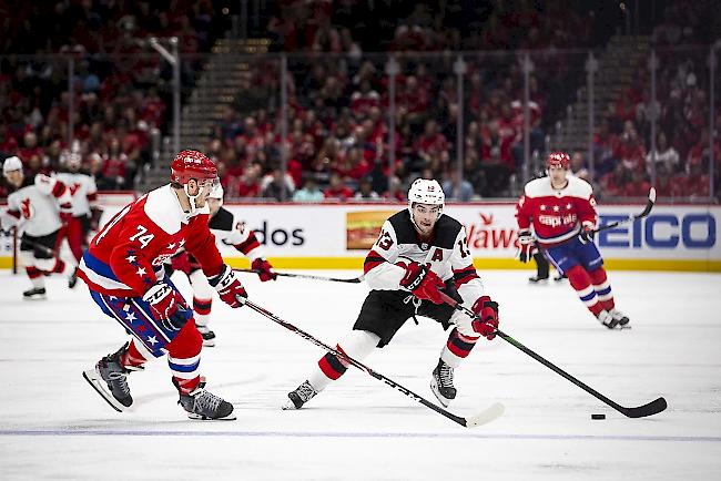 New Jersey Devils-Center Nico Hischier (13) zieht den Puck am Verteidiger John Carlson (74) von den Washington Capitals vorbei. (Archivbild)