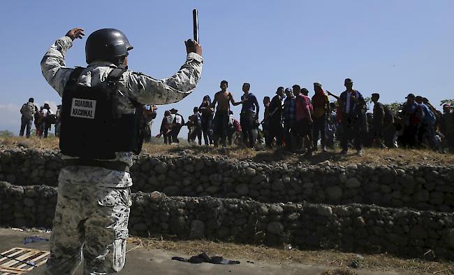 Zentralamerikanische Migranten nähern sich einem Soldaten der mexikanischen Nationalgarde, nachdem sie den Suchiate-Fluss von Guatemala nach Mexiko überquert haben.