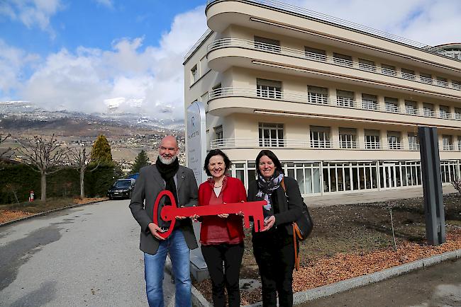 Olivier Salamin, Vizepräsident von ProjetSanté übergibt den Schlüssel zum neuen Alters- und Pflegeheim an Laetitia Massy, Präsidentin SMZ Region Siders (rechts). Staatsrätin Esther Waeber-Kalbermatten wünscht sich mehr solcher Projekte im Kanton. 