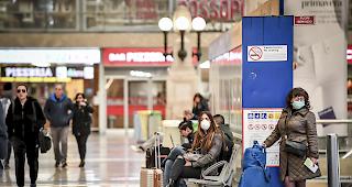 Menschen mit Gesichtsmasken am Sonntag im Mail&auml;nder Hauptbahnhof.